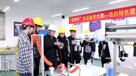 王建華老師指導學生操作機器人.jpg